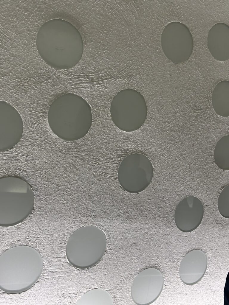 Wand seitlich der Rolltreppen